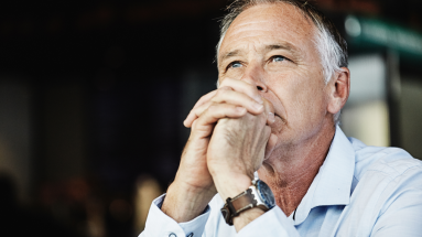 Man with hands intertwined  while looking upward 