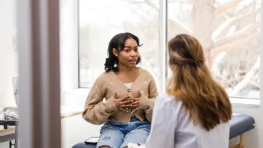 Young lady in doctor's exam room with female HCP