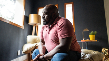 Man sitting on couch staring out of the window 