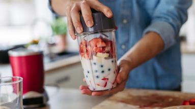 An unblended smoothie that contains milk, strawberries, blueberries, and bananas