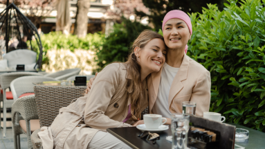 Two women hugging while sitting down