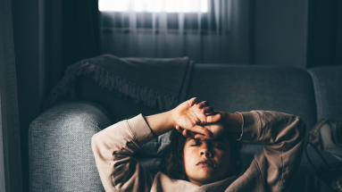 lady laying on couch with hands on head