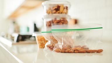 nuts in ziploc baggy and glass containers on kitchen counter 