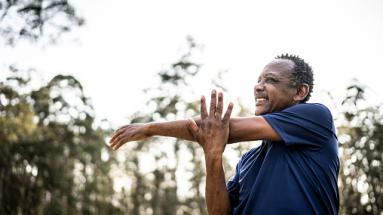 Man stretching his left arm over his right arm