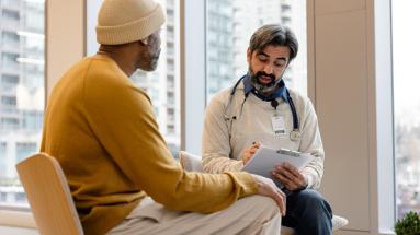 A physician and patient sitting and talking 