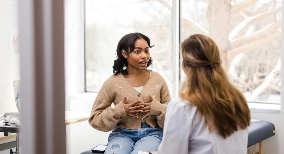 Young lady in doctor's exam room with female HCP