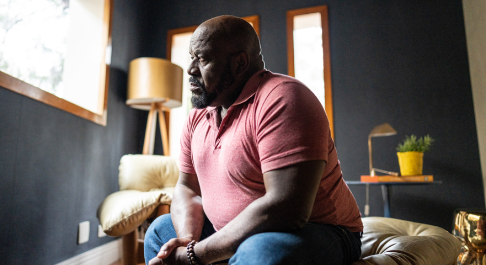 Man sitting on couch staring out of the window 