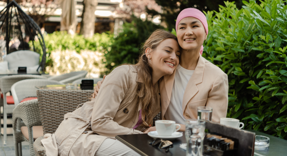 Two women hugging while sitting down