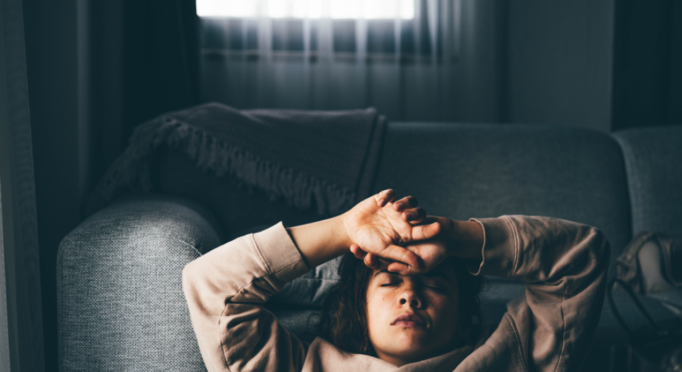 lady laying on couch with hands on head