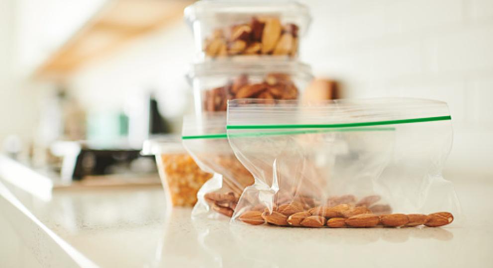 nuts in ziploc baggy and glass containers on kitchen counter 