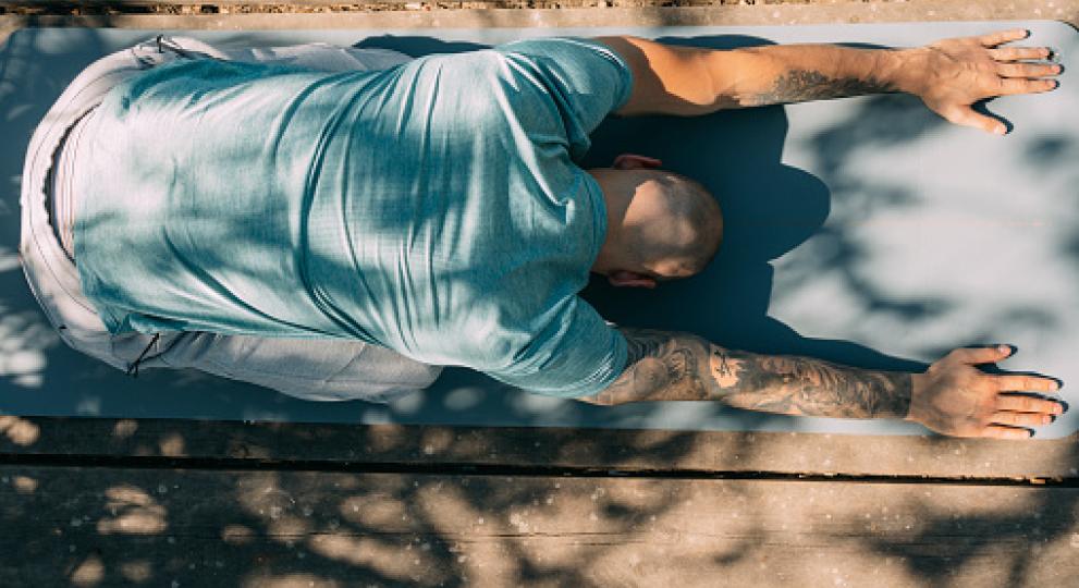 Man doing downward dog yoga pose 